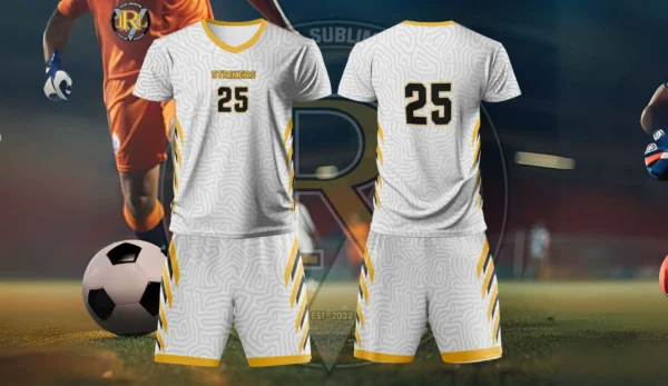 A white and gold soccer jersey set with "STRIKERS" and the number "25" on the front, and "25" on the back. The jersey has a subtle pattern, and the set includes matching shorts. In the background, a partial view of a soccer player and a soccer ball are visible, along with the "Regar Sport Indonesia" logo.